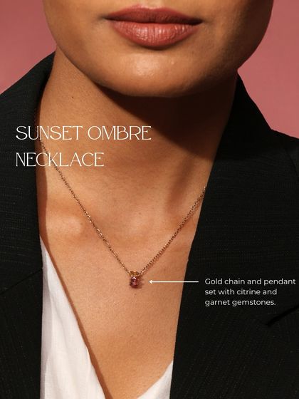 The Sunset Ombre Necklace, a delicate gold chain and pendant set with a warm gradient of citrine and garnet gemstones.
