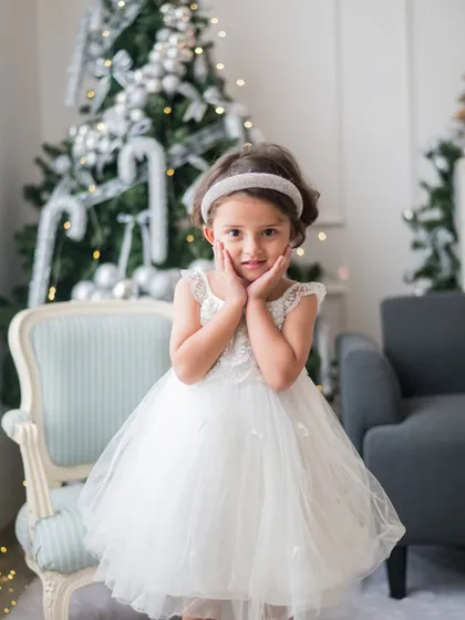 Capturing the pure innocence and wonder of childhood is what makes holiday photos so special. This little girl's sweet expression in front of the Christmas tree is a perfect memory frozen in time.