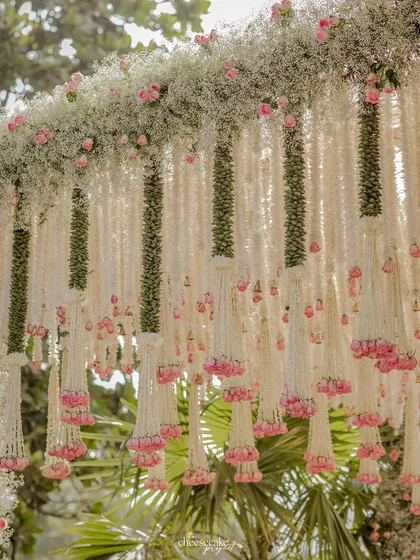 The full arch of the mandap, showcasing how the floral design extends from the pillars to the canopy, creating a complete floral haven.