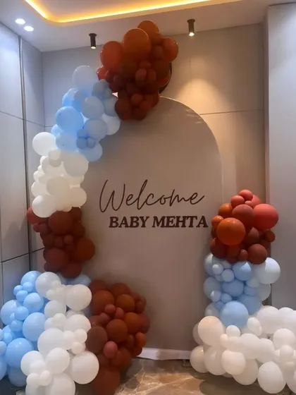 A simple and modern welcome home decoration for Baby Mehta. The balloon arrangement in rust, blue, and white offers a unique and stylish color combination for a contemporary family.