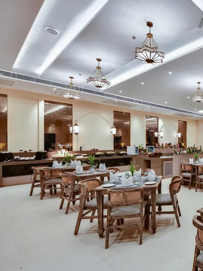 Another perspective of the restaurant at The Fern Sattva Resort. The design focuses on clean lines and uncluttered spaces, allowing the textures of the materials and the quality of the light to define the atmosphere.