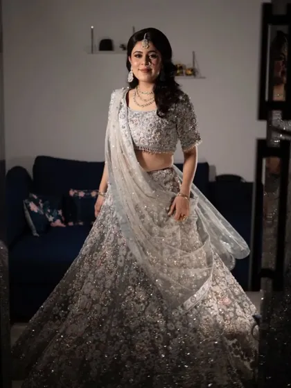 This shot captures the beautiful sparkle of the lehenga and the soft elegance of the hairstyle. It's a complete look designed for a grand celebration.