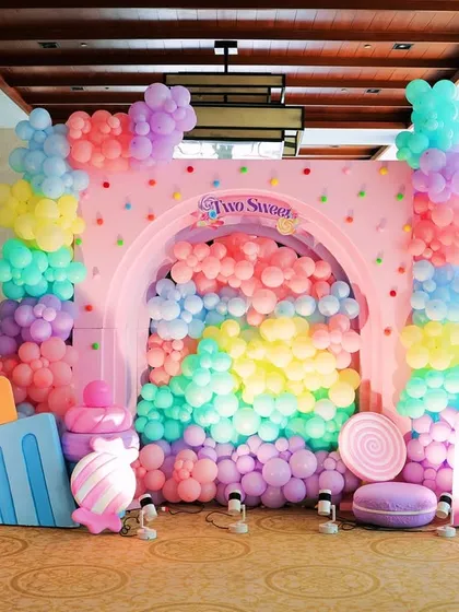 I designed this vibrant Candyland themed photo booth as a sweet spot for pictures. It features a cascade of pastel balloons pouring through an arched backdrop, surrounded by giant lollipops, ice cream props, and a custom light up sign.