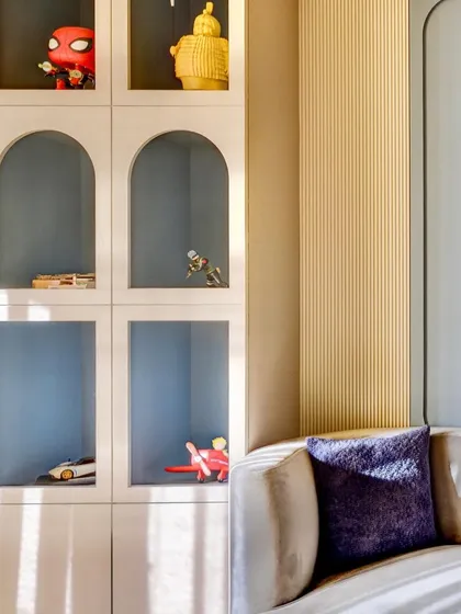 A detail shot of the arched shelving unit in a kid's room, perfect for displaying toys and treasures. The design is both practical for storage and visually appealing.