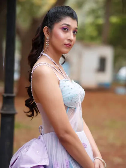 A side profile that highlights the soft curls in the ponytail hairstyle.