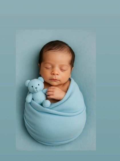 Snuggled in a cozy blue wrap with a tiny teddy bear, this little one is the picture of peaceful sleep. I use simple, sweet props to add a touch of personality while keeping the focus entirely on your baby's adorable features.