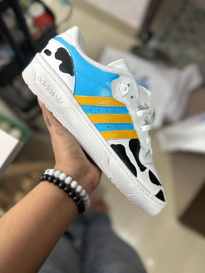 A fun, cow-print themed Adidas custom with blue and yellow accents.