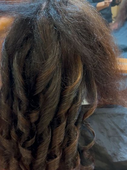 The styling process for men's hair. Creating defined curls and texture requires skill and the right products to achieve a look that is both stylish and manageable.