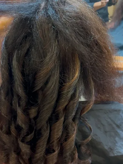 The styling process for men's hair. Creating defined curls and texture requires skill and the right products to achieve a look that is both stylish and manageable.