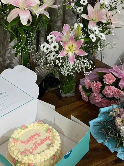 The joy of gifting. A lovely birthday cake, beautifully boxed and surrounded by fresh flowers, ready to make someone's day.