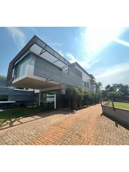 The entrance to the office campus is marked by a dramatic cantilevered volume, creating a sheltered drop-off area. The building has settled into its landscape over the past decade.