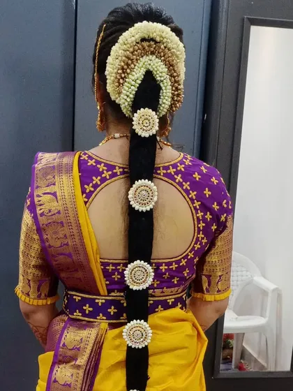 My specialty, the traditional Poola Jada. This intricate floral hairstyle uses fresh flowers and classic hair jewelry, making it a timeless choice for a South Indian bride.
