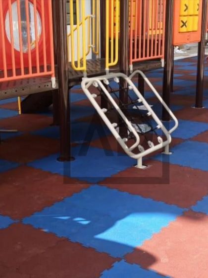A close-up of interlocking rubber tiles at a playground. These heavy-duty tiles provide excellent fall protection and are durable enough for public parks and schools.