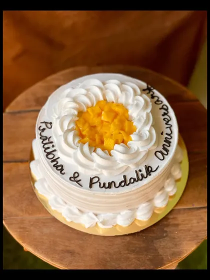 Another beautiful mango cake for an anniversary, showing the simple and elegant piping work.