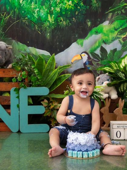 A jungle-themed cake smash! This little explorer is having a wild time celebrating his first birthday with his animal friends.