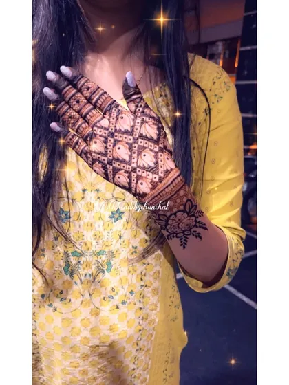 A unique design with a jaal pattern made of tiny elephants, covering the back of the hand.
