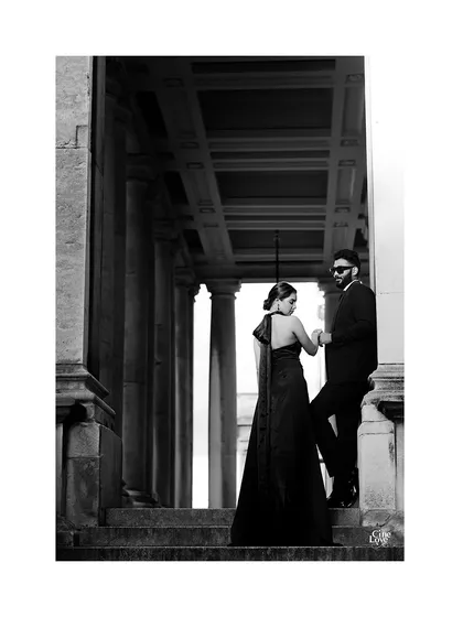 A black and white shot emphasizing the dramatic silhouette of the bride's gown against London's classical architecture. Styling is also about creating powerful shapes and moods.