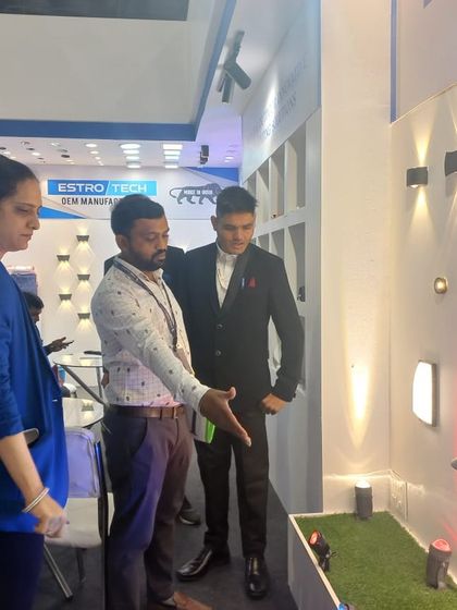 Visitors explore a display of modern wall-mounted and garden lights, perfect for architectural and landscaping projects.