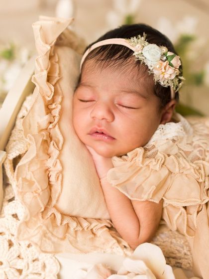 The perfect newborn pose. This baby girl is sleeping peacefully with her hands tucked under her chin, a classic and beautiful fine art newborn portrait.