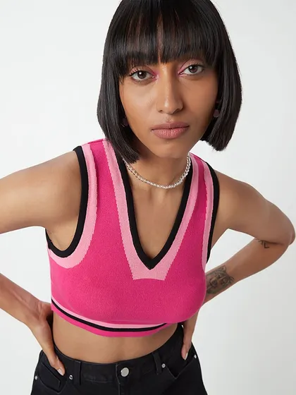 A fun and edgy look for Westside, featuring a sharp bob and a pop of pink in the inner corner of the eye. This makeup complements the sporty, colorful top.