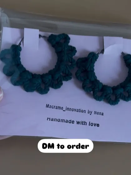 A pair of my crochet hoop earrings in a deep bottle green. The scalloped edge design gives them a unique, floral-inspired look.