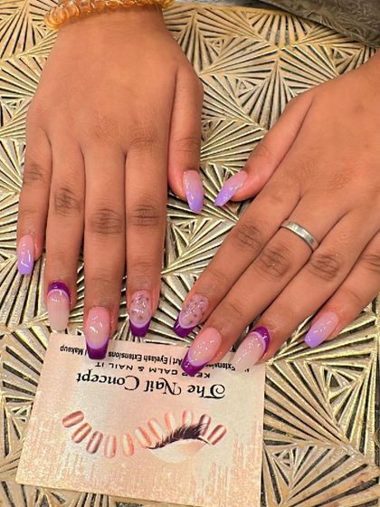 A colorful and stylish set of long, square nails. The design features a mix of solid lavender nails and a purple French tip, with a subtle glitter accent.