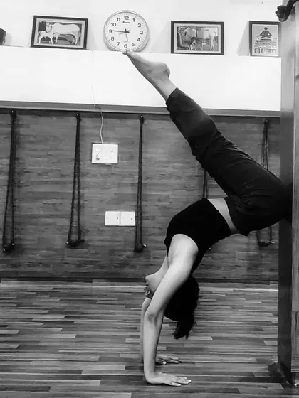 Using a wall as a prop to work on a forearm stand split. The wall provides support and helps build the confidence and alignment needed for freestanding inversions.