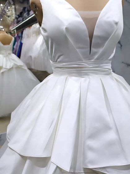 A modern take on the classic white ball gown. I designed this with a deep V-neck and a structured, layered satin peplum over a soft tulle skirt for a look that is both chic and dramatic.