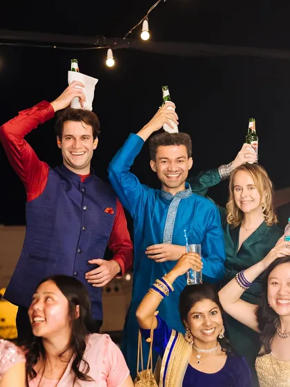 A hilarious and candid moment of guests balancing beer bottles on their heads during the party.