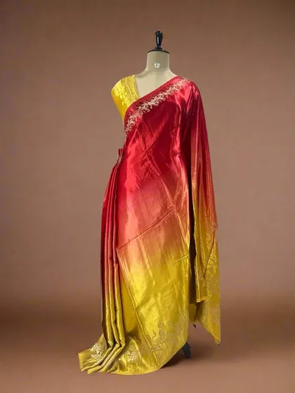 A fiery shaded satin crepe saree with a flamingo border, transitioning from red to yellow.