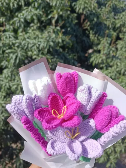 A custom bouquet featuring purple and pink flowers, wrapped and ready to go.