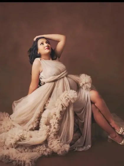 A dramatic pose in our beige ruffled gown. The high-low design and voluminous train create a powerful and fashionable silhouette.