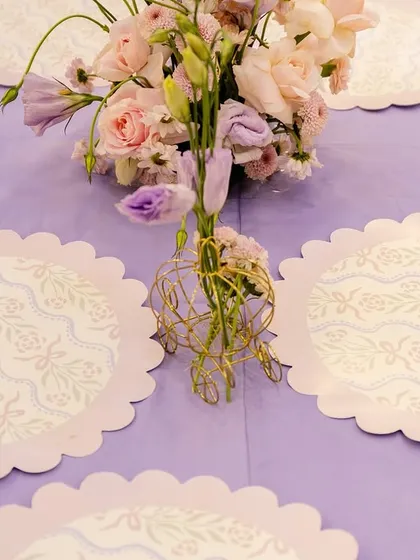 Custom scalloped placemats with a delicate pattern complemented the lavender tablecloths and soft floral arrangements at the princess party.
