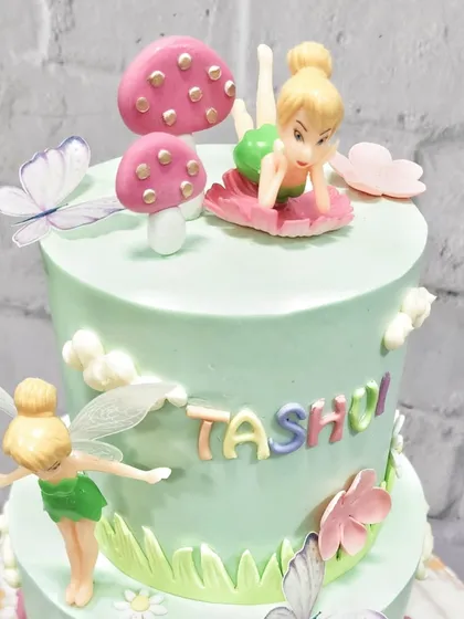 The top tier of our fairy garden cake, where Tinkerbell is relaxing on a flower. I love adding these small, playful details that kids notice and love.