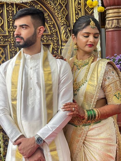 A side profile showcasing the bride's elegant updo and the details of her embroidered blouse and jewellery.