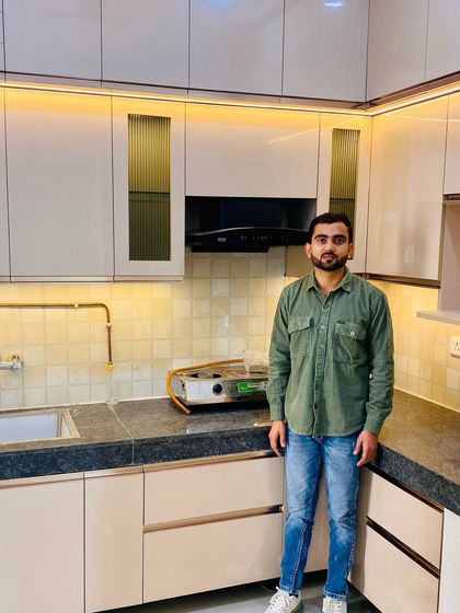 A finished kitchen project featuring beige cabinets, fluted glass shutters, and warm under-cabinet lighting.