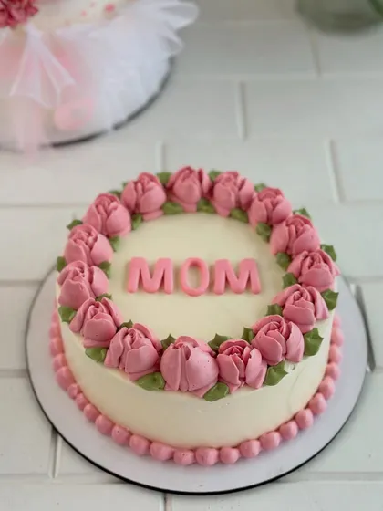 A simple and sweet "MOM" cake, framed by a wreath of hand-piped pink buttercream tulips.