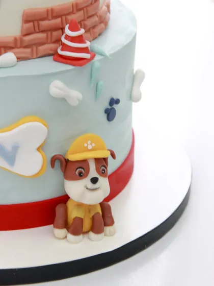 Detail shot of the Rubble fondant figure on the Paw Patrol cake, showcasing the small, handcrafted elements that bring the character to life.