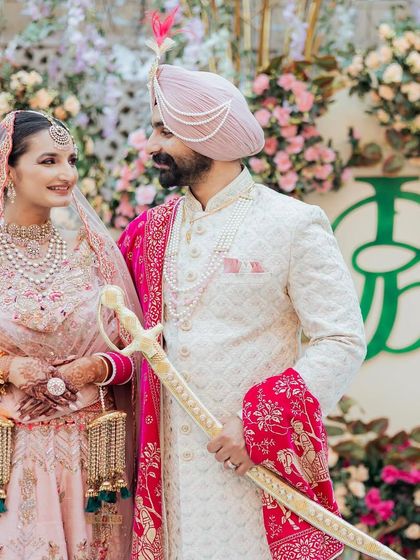 A candid moment from a beautiful Sikh wedding, with the couple sharing a look in front of the custom monogram I designed. It shows how a simple logo can elevate the entire aesthetic of the wedding decor.