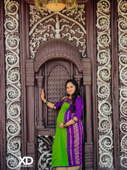 A confident solo pose by the mother-to-be against a grand traditional door.