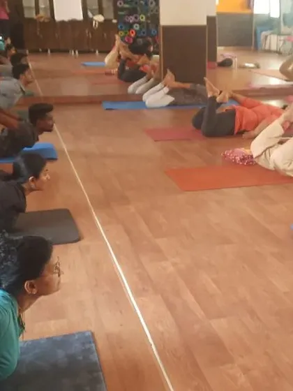 A wide view of the studio during Dhanurasana (Bow Pose) practice. You can see students at different levels of flexibility working on this powerful backbend.