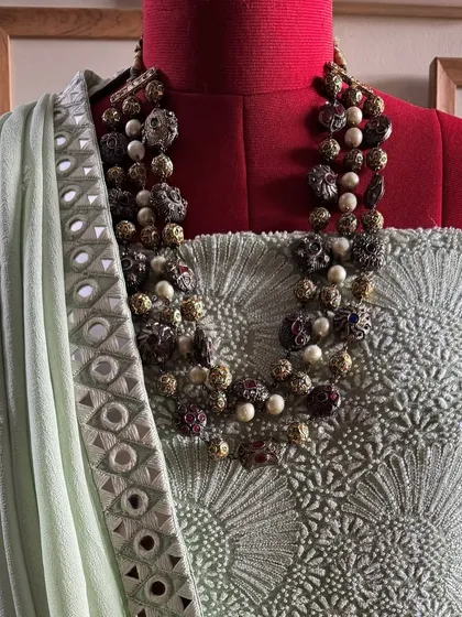 A close-up of the kurta's yoke, showing the dense Chikankari jaal, styled with a necklace.
