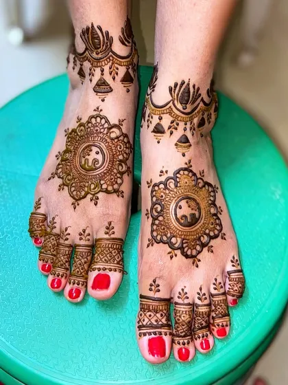 A lovely foot design with a central mandala featuring a small elephant, with delicate patterns on the toes and ankles.