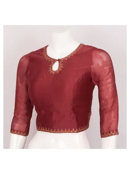 I specialize in delicate details, like this maroon blouse featuring sheer sleeves and an elegant keyhole neckline. The fine embroidery along the neck and cuffs adds a touch of sophistication, making it an ideal choice for party wear or festive events.