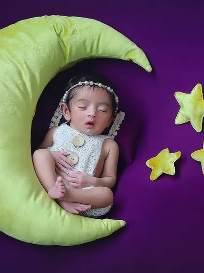 A sweet baby girl sleeping on a crescent moon prop under the stars. This celestial theme is a classic for newborn photography and always looks so magical and dreamy.