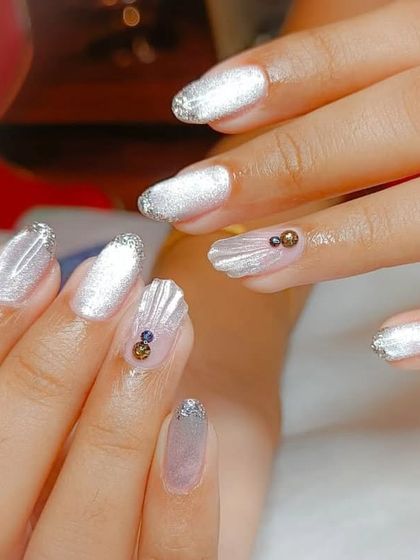 A mermaid-inspired design featuring a shimmery white base, 3D shell textures, and delicate rhinestone accents.