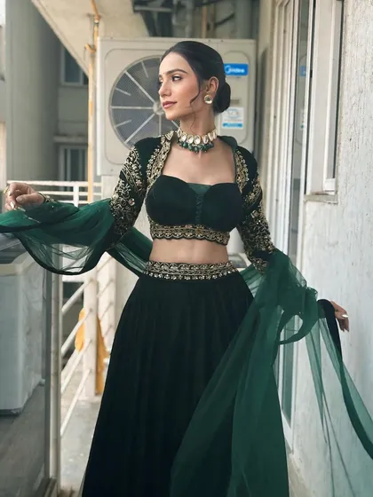 A full-length shot showcasing the dramatic sleeves and flow of the lehenga. The entire look is balanced, with the makeup complementing the outfit perfectly.
