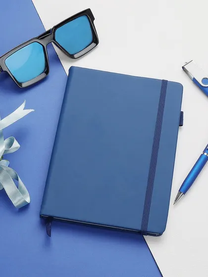 We excel at creating styled flat lay compositions that enhance product appeal. This arrangement of a blue corporate notebook set with complementary accessories shows how we build a visual narrative for your brand, perfect for social media and website banners.