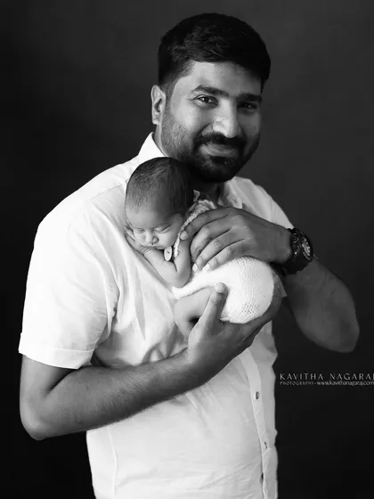 A father holds his newborn, a quiet moment of bonding. This black and white portrait is a timeless tribute to the special connection between a dad and his baby.