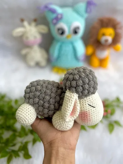 A sleepy, cuddly sheep with a fluffy grey body made from bobble stitches. This is a perfect naptime companion for a little one.